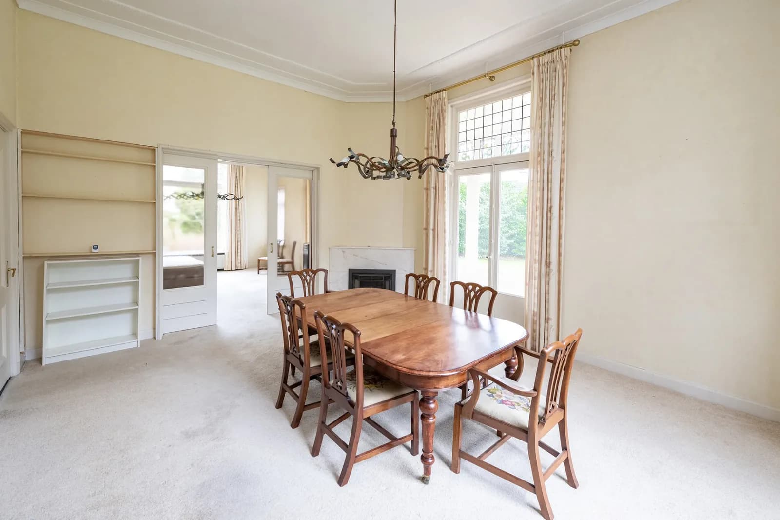Original Dutch dining room with dark wood dining set and a traditional chandelier
